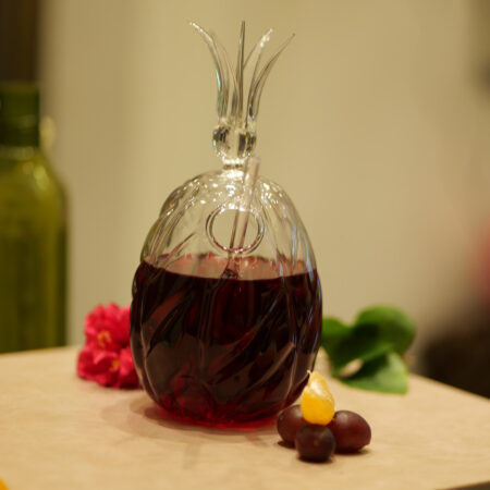 Transparent pineapple-shaped glass with leaf crown for tropical cocktails and summer drinks